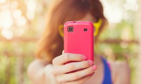 Girl taking a photo with her pink smart phone