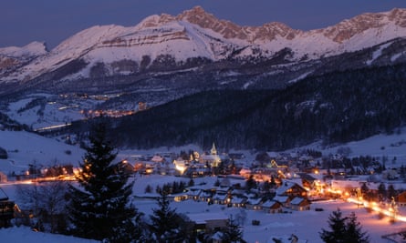town in valley with lights under snowy mountain