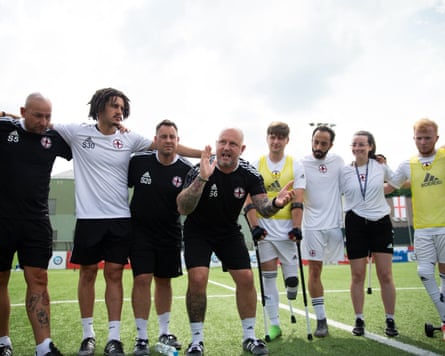 Scott Rogers (fourth from left), the head coach of the England men’s amputee team, gives a teamtalk on the the pitch during a Nations League match.