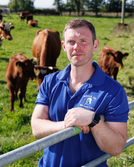 Mossgiel Organic Farm, Mauchline, East Ayrshire. Bryce Cunningham, farmer and owner of Mossgiel Organic Farm near Mauchline is pictured in a field with some of his herd of Ayrshire cows.