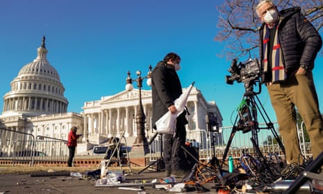 Members of the news media survey damaged equipment outside the US Capitol a day after a mob of Trump supporters breached the building.