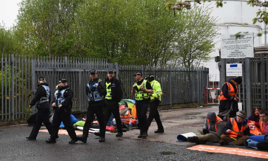 Just Stop Oil blockades terminal in Glasgow in first Scottish action | Just Stop Oil 1 Police officers walk past Just Stop Oil activists blocking the entrance to the Nustar Clydebank oil terminal in Glasgow