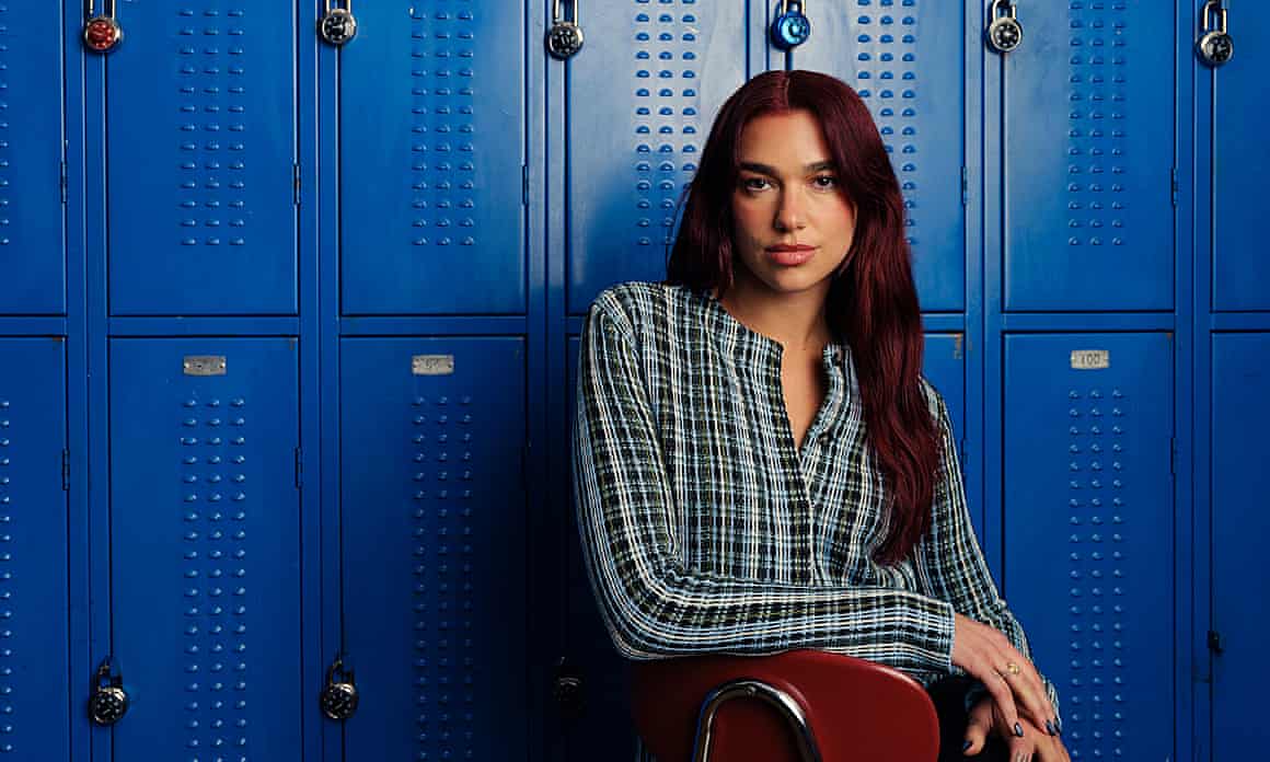Dua Lipa, pictured in front of rows of blue lockers