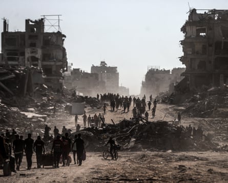 Palestinians, carrying their belongings return from the south to the north of Gaza's Sheikh Radwan and Al-Jala Street