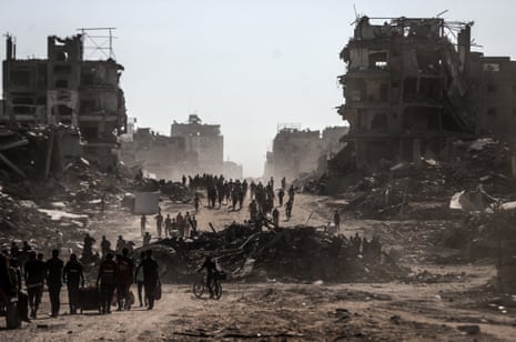 Palestinians, carrying their belongings, return to the north of Gaza’s Sheikh Radwan as the ceasefire took effect in the Gaza Strip.