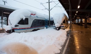 Snow-covered trains sit stranded at Berchtesgaden station