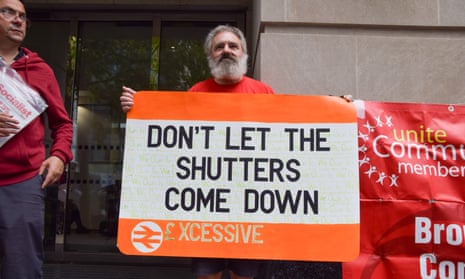 A protest against the closure of rail ticket offices outside the Department for Transport in London. Sign resembling a rail ticket reads "Don't let the shutters come down"