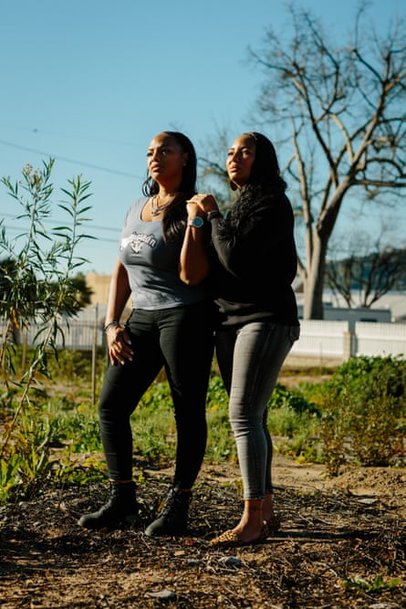 Two women pose for a portrait outside