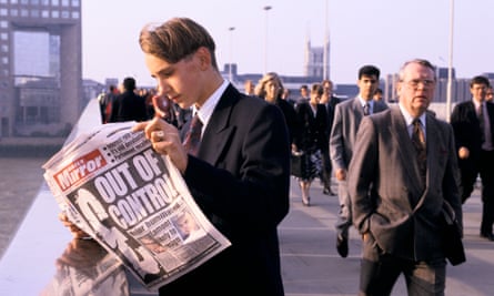 A man in a suit holds a newspaper