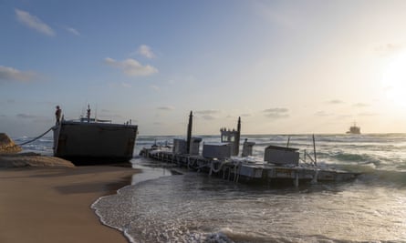 An American soldier stands on a a US military vessel that ran aground at a beach in the Israeli city of Ashdod on Saturday.