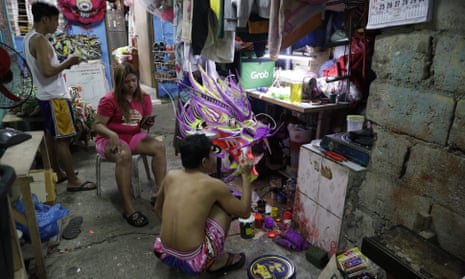 Robert Sicat paints a dragon head, but members of his Dragon and Lion dance group must seek other ways to earn a living this year in Manila’s Chinatown.