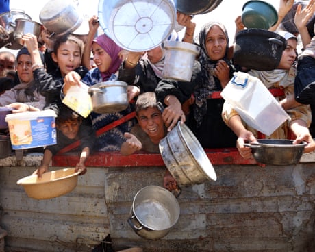 Palestinians crowd at a lentil soup distribution point in Gaza City, among them children and women holding pot and pans