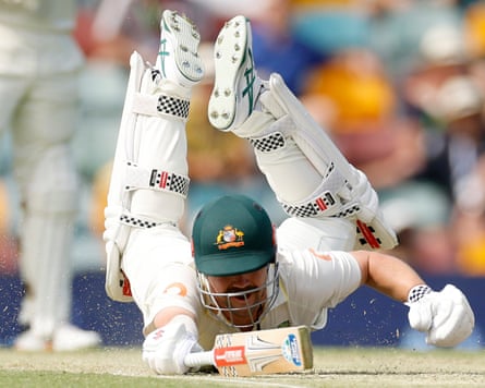 Travis Head dives to avoid a run-out at the Gabba