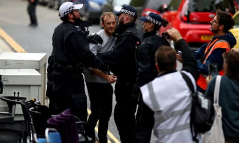 Police detain a man during a raid on the Extinction Rebellion storage facility.