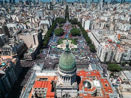 aerial view of thousands of protesters in front of grand building