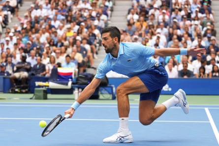 Novak Djokovic plays a backhand to Carlos Alcaraz.
