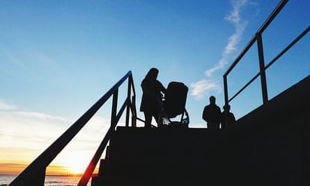 Silhouette d'une femme avec un landau en haut de l'escalier, à l'extérieur.