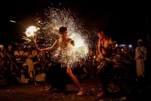 People are hit with burnt, dried coconut leaves during the fire fight ritual in Klungkung ahead of the Balinese Day of Silence.