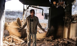 A man looks in shock at his destroyed house in Cizre.