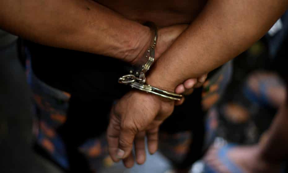 An alleged drug dealer is handcuffed during a police operation conducted in Manila, Philippines. 