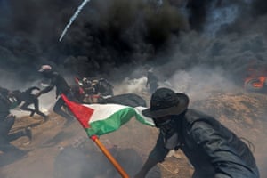Palestinian demonstrators run for cover from Israeli fire and teargas during a protest against the opening of the US embassy in Jerusalem and ahead of the 70th anniversary of Nakba