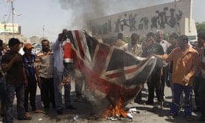 A crowd burn a British flag to protest the 2003 killing of 26-year-old Baha Mousa.