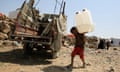 A displaced Yemeni child carries water containers donated by Unicef at a camp on the outskirts of Sana'a, Yemen, last year.