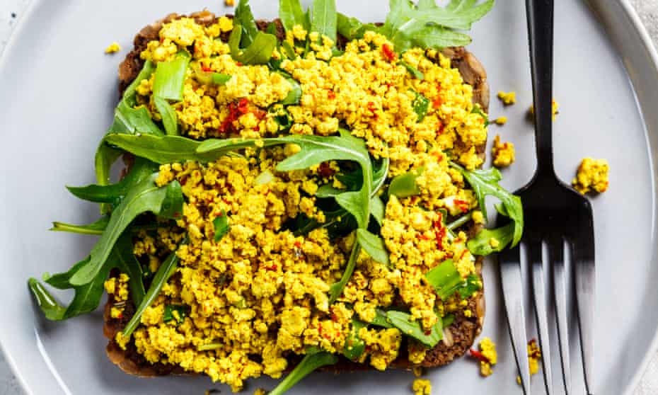 Tofu scramble toast with greens on rye bread, top view. 