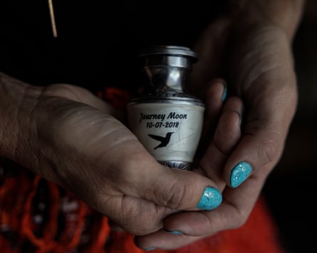Scottsdale, Arizona, August 22, 2025 Lorren Hollidays poses for a photo holding a urn containing the ashes of her daughter Journey Moon in their hotel room in Scottsdale, Arizona, on August 22, 2025. Her daughter, Journey Moon, was one of the first babies to die from the Free Birth Society community. Lorren attempted to free birth at home where they lived in the desert. She was targeted afterwards with death threats. (Photo by Adriana Zehbrauskas for The Guardian)