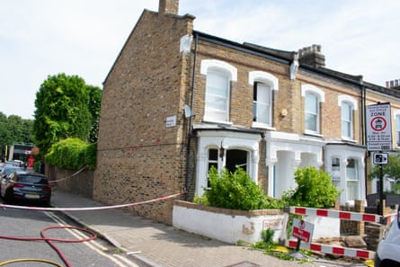 An end-of-terrace Victorian house with the front windows on the ground floor blown out. The area around the house has been cordoned off.