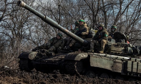 Ukrainian service members ride atop of a tank outside of the frontline town of Bakhmut, amid Russia’s attack on Ukraine, in the Donetsk region.