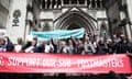 Post office workers outside of the Royal Courts of Justice hold a banner