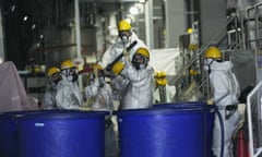 Workers in hazmat suits remove radioactive materials from contaminated water at the Fukushima Daiichi nuclear power plant