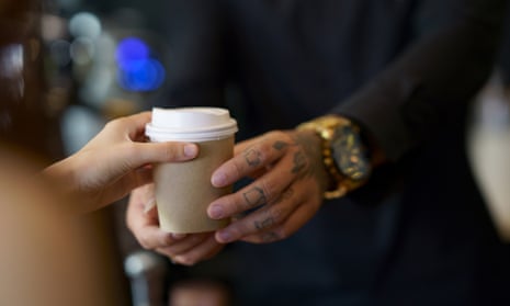 Barista serving coffee in a takeaway paper cup