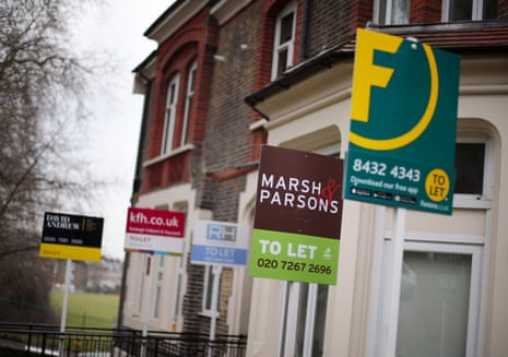 Several "To Let" letting agent signs stand outside a row of brick houses in north London