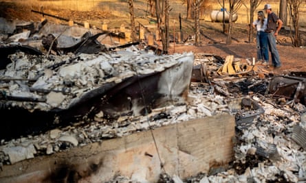 Residents Cody Najera, right, and Arizona Erb look through the remains of their burned home in Greenville, California, on 4 September.