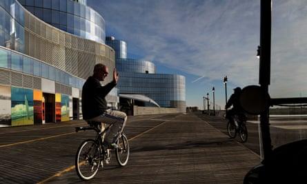 Atlantic City Mayor Don Guardian waves at a local walking the boardwalk as he passes the huge shuttered Revel casino.