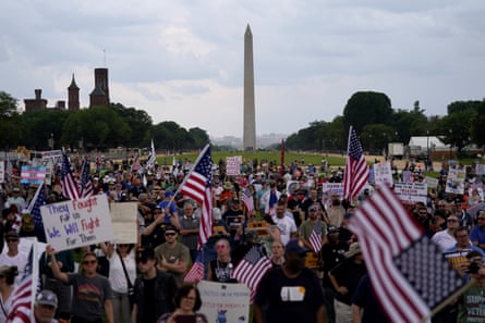 people with flags and signs in front of the Washington Monument