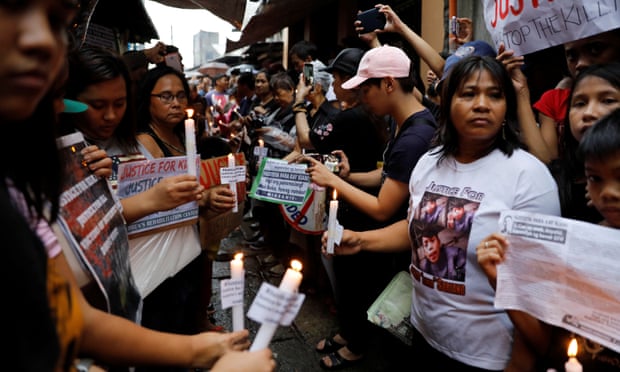 Protesters and residents hold lighted candles and placards at the wake of Kian Loyd delos Santos, a 17-year-old high school student, who was among the people shot dead last week in an escalation of President Rodrigo Duterte’s war on drugs in Caloocan city, Metro Manila, Philippines