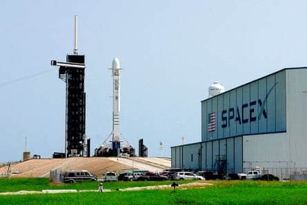 A rocket and warehouse at a SpaceX launchpad