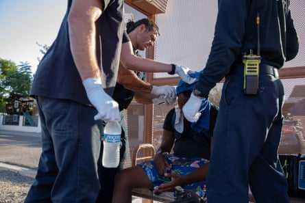 Firefighters from Phoenix Fire Engine 18 measure the body temperature of a resident having trouble breathing during a heat wave in Phoenix, Arizona, US