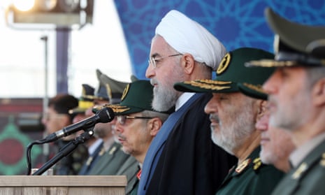 Iranian president Hassan Rouhani, centre, watches the annual military parade where he gave his speech