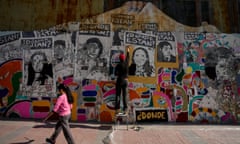 A woman works to restore a mural in honour of those executed and disappeared under the Pinochet dictatorship, featuring the question ‘where are they?’