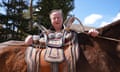 David Cameron stands behind the saddle of a horse
