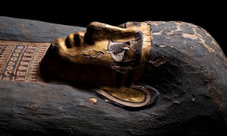 Coffin and mummy of Tasheriankh. The coffin is in a shape known as ‘anthropoid’ or ‘mummiform’, representing the deceased in a transfigured, god-like form. The coffin has a gilded face and a tripartite wig, painted blue.