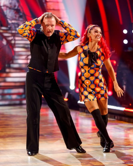 A portrait shot of Chris McCausland and Dianne Buswell doing trheir Strictly Come Dancing, the former with hands on head
