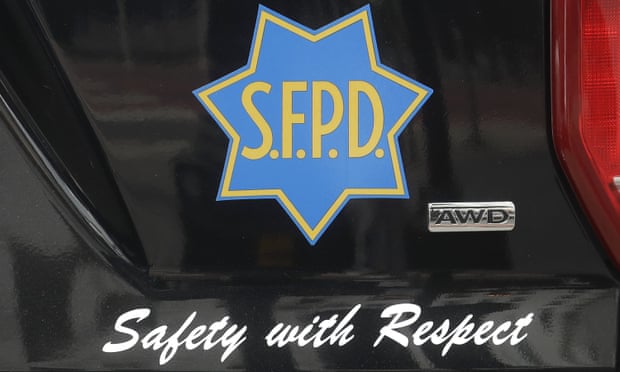 A logo of the San Francisco police department is on the side of a police car with the motto "Safety with respect" written below.