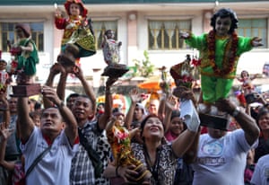 Manila, PhilippinesDevotees raise figurines of the Santo Nino as known as Holy Child Jesus, to be blessed with holy water during the annual feast day of Santo Nino in Tondo