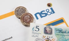 New £1 pound coins, £2 pound coins and £5 pound notes on an Premium Bond document<br>HY8HPN New £1 pound coins, £2 pound coins and £5 pound notes on an Premium Bond document