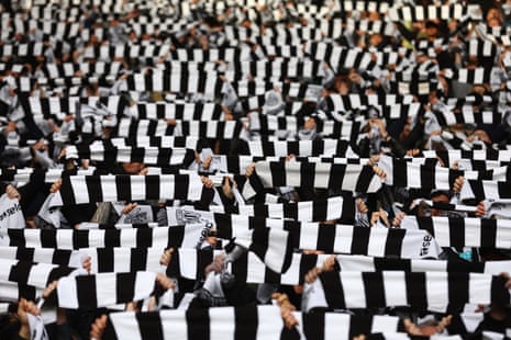 Newcastle United fans display scarves inside the stadium before the match.